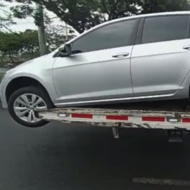 Denuncian traslado de carro en una grúa con parte de su carrocería en el aire